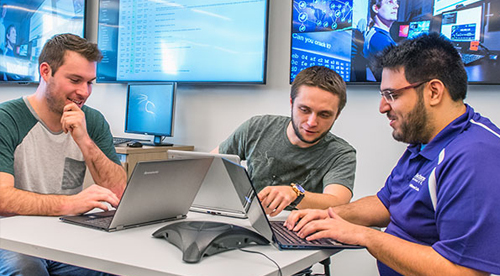 Three students work on laptops.
