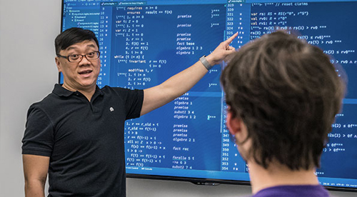 Professor explains code displayed on a large screen.